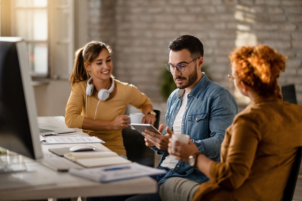 Young businessman using touchpad while having a meeting with fem